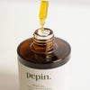 Bottle of 'pepin.' neem oil with a dropper on a light background
